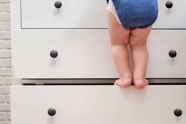 baby on dresser about to break a drawer