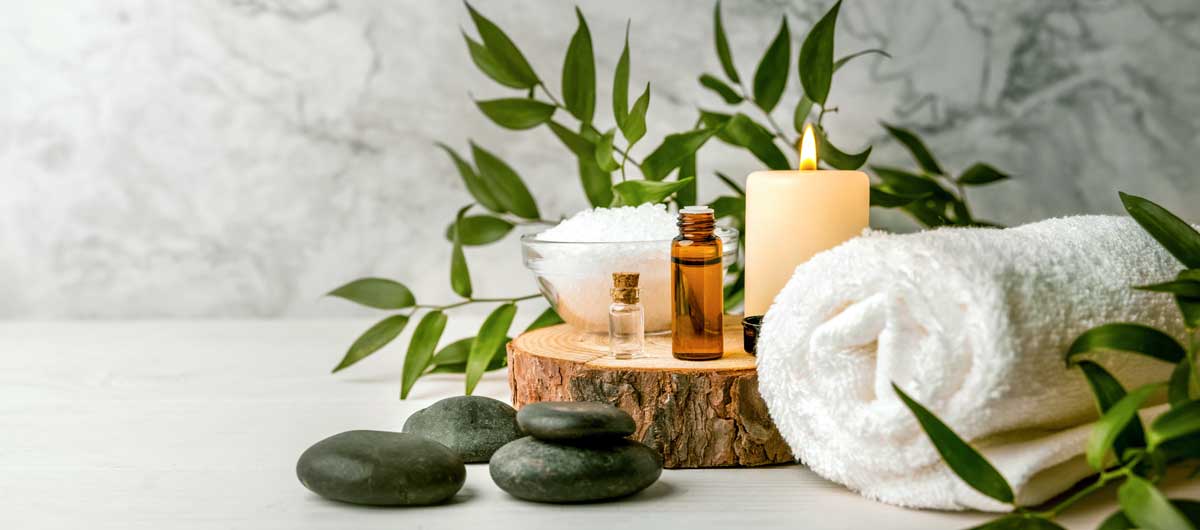 Spa candles, towel, and aromatherapy bottle evoking relaxation and wellness in Colorado interior design retreats
