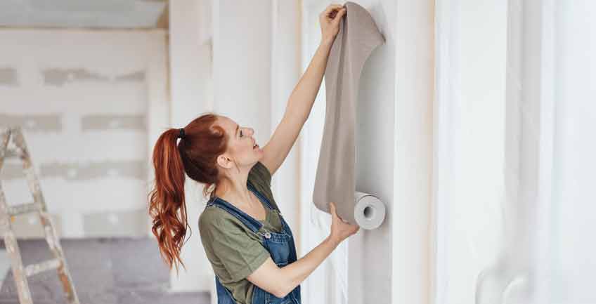 woman installing wallpaper