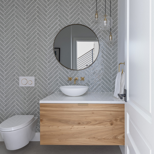Herringbone tile wall and wall-hung toilet in Boulder Scandinavian-inspired bath